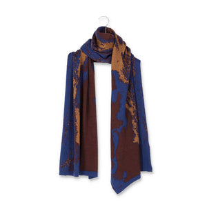 Packshot of a knit scarf in blue and brown with gold and copper details.